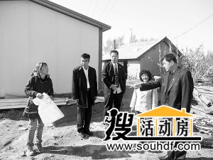 法院的領(lǐng)導在查看老人居住的彩鋼房